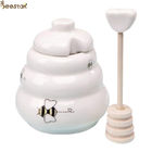 卸し売り白い空の蜂蜜の瓶の蜂蜜の貯蔵のための木のディッパーが付いている陶磁器の蜂蜜の鍋