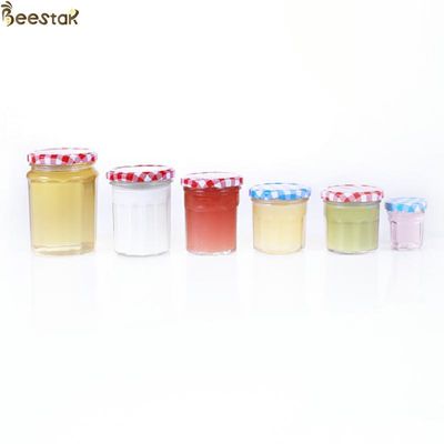 薄いねじ金属のふたが付いている150ml 200ml 250ml 380mlの蜂蜜の瓶およびスプーンの広い口
